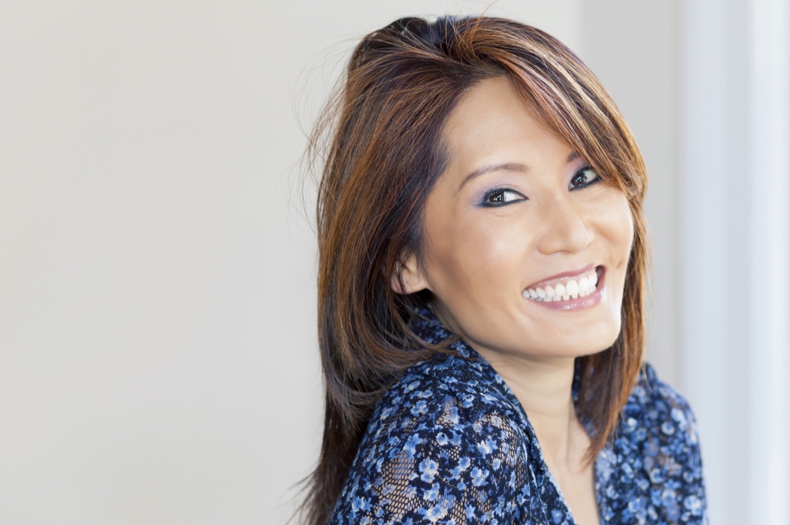 A woman smiling, looking back over her shoulder
