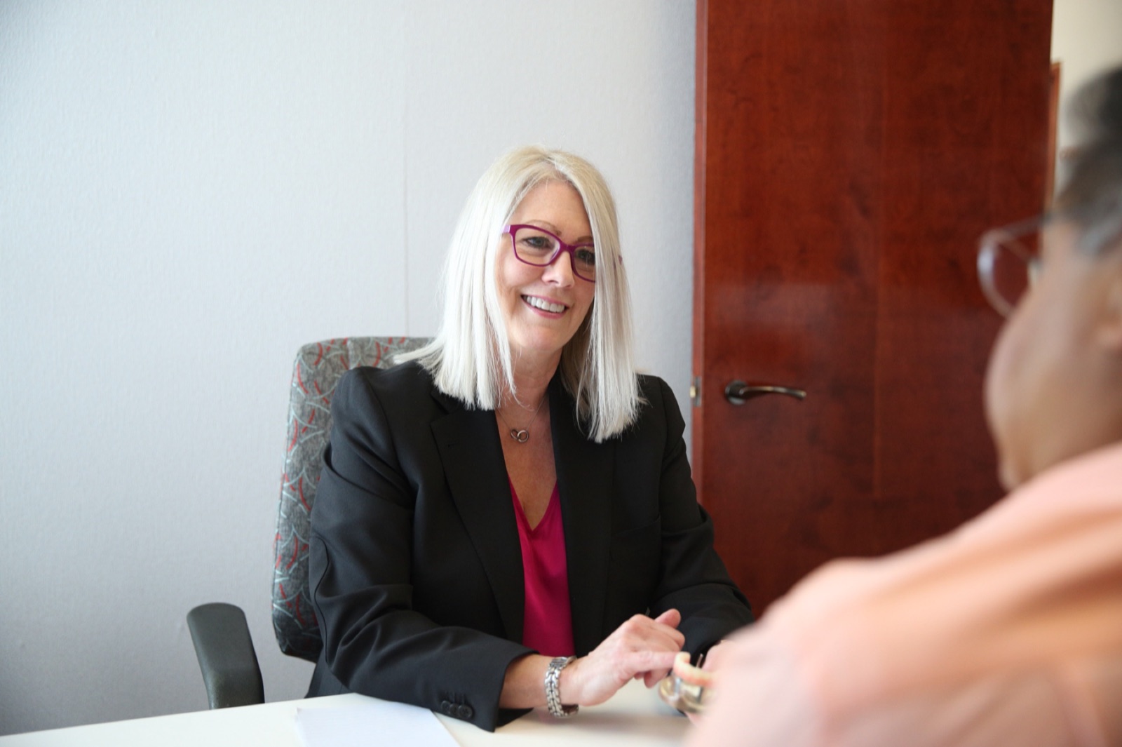 A member of our team talking with a patient across a consultation table