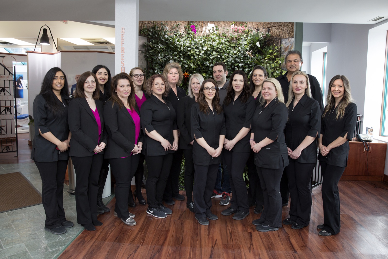 Our team gathered in front of the living plant wall in reception