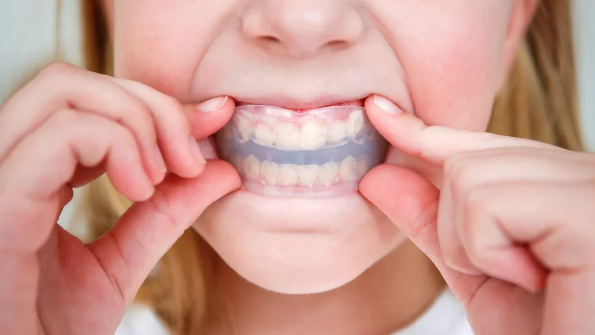 Person protecting teeth with custom guard