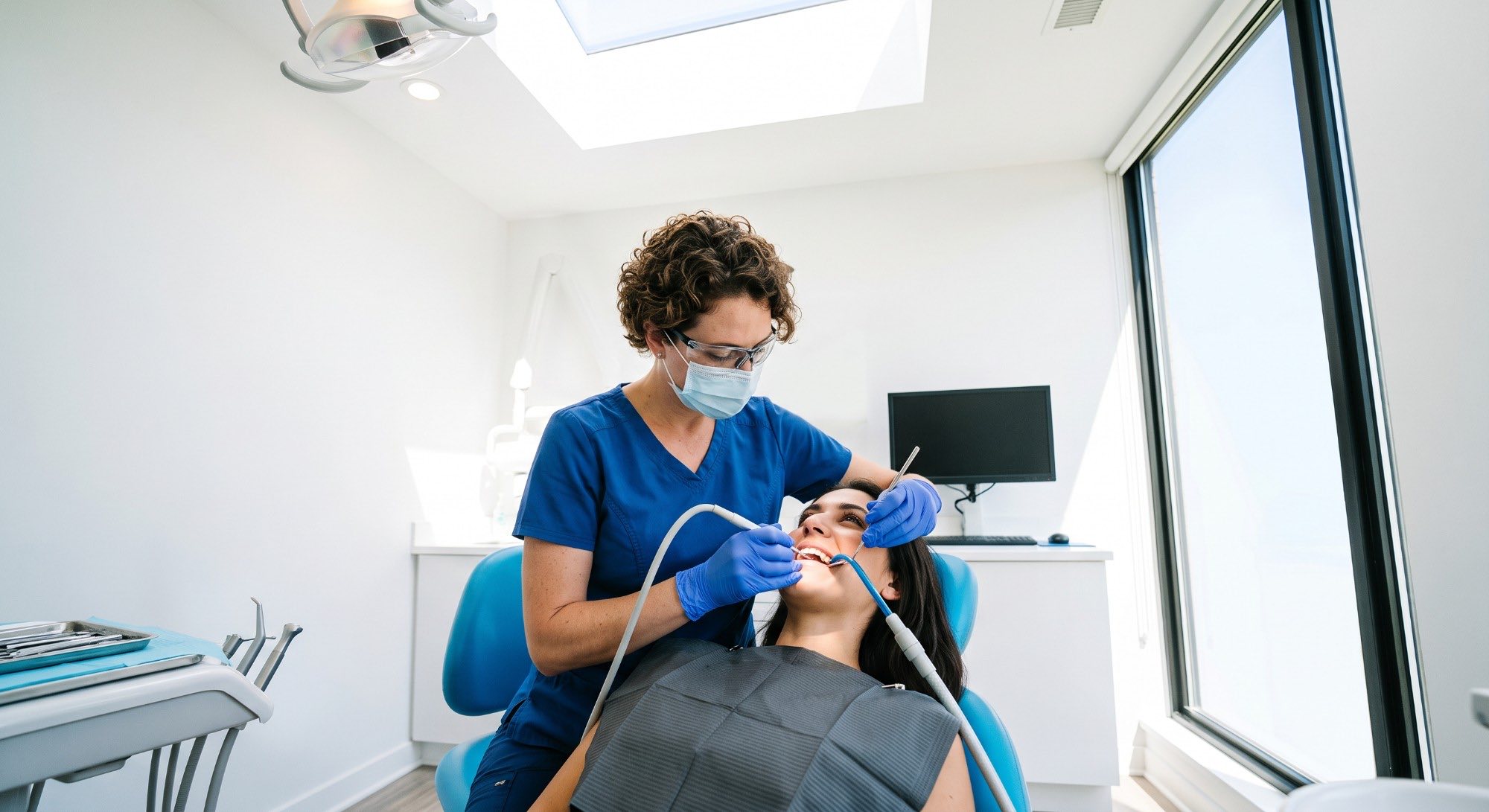 A hygienist cleaning along a patient's gumline during a check-up
